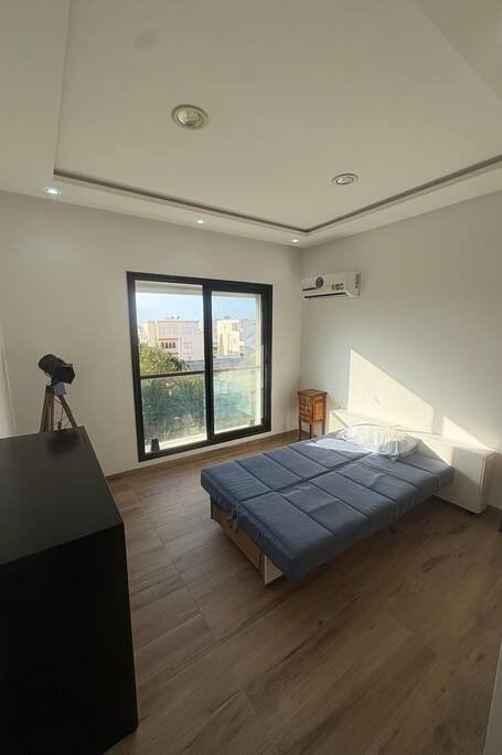 La seconde chambre vue depuis l'entrée, meuble bas et fenêtre