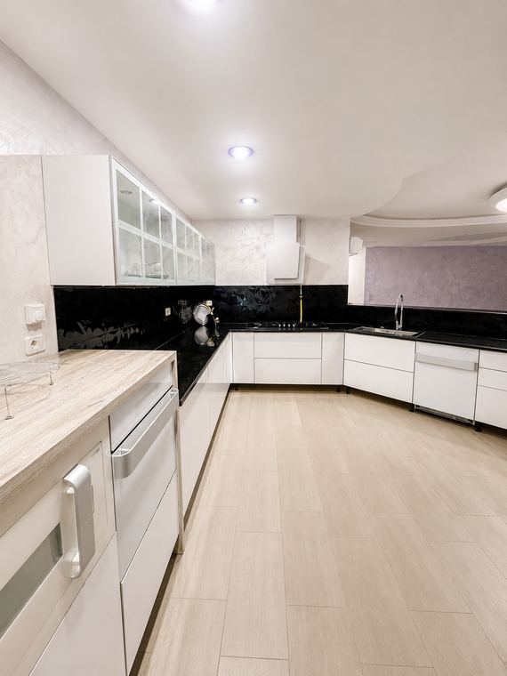 Cuisine en U, façades laquées blanches et plans de granit noir