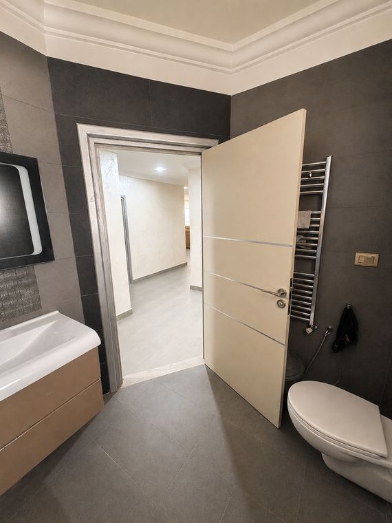 Salle de douche du couloir : plan vasque, WC suspendu et sèche-serviettes