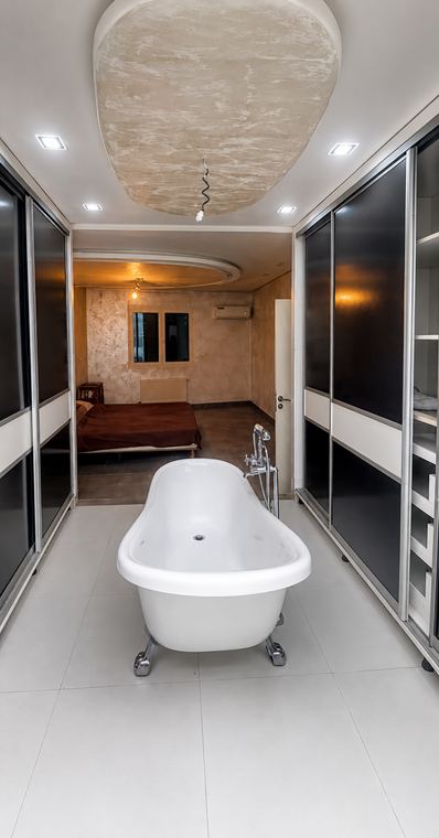Die freistehende Wanne der begehbaren Ankleide, zum Schlafzimmer hin offen