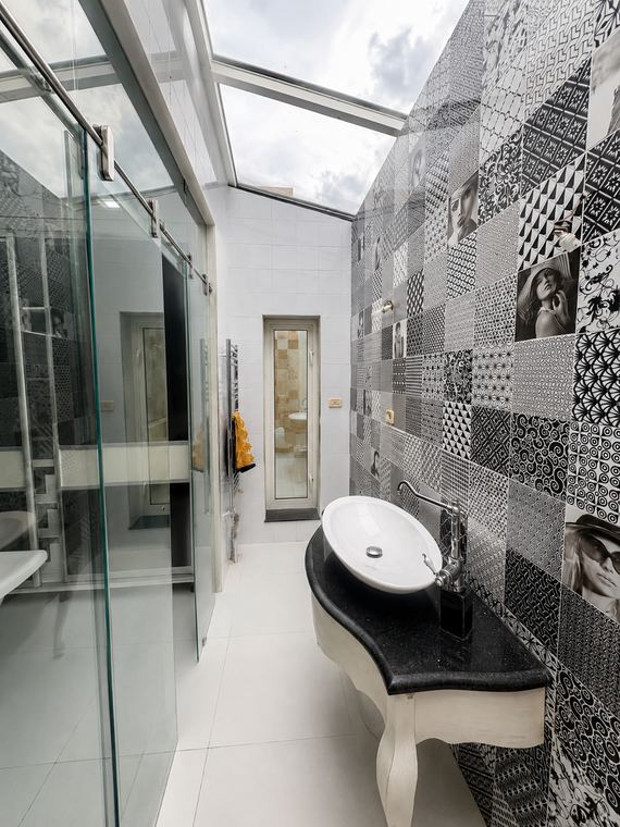 La salle d'eau parentale sous sa verrière zénithale, mur de carreaux noir et blanc